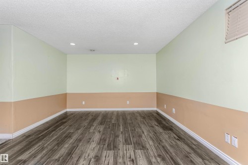 Unfurnished room with dark wood-style flooring, a textured ceiling, and recessed lighting - 607 Windross Crescent, Edmonton, AB - Indoor Photo Showing Other Room