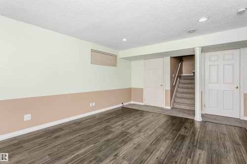 Finished below grade area featuring dark wood-style flooring, a textured ceiling, and recessed lighting - 607 Windross Crescent, Edmonton, AB - Indoor Photo Showing Other Room