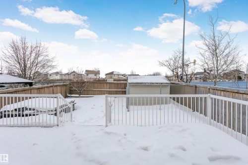 Yard layered in snow with a wooden deck, a residential view, a fenced backyard, and an outdoor structure - 607 Windross Crescent, Edmonton, AB - Outdoor