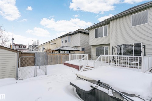 Yard layered in snow with a gate, a wooden deck, and a hot tub - 607 Windross Crescent, Edmonton, AB - Outdoor With Deck Patio Veranda With Exterior