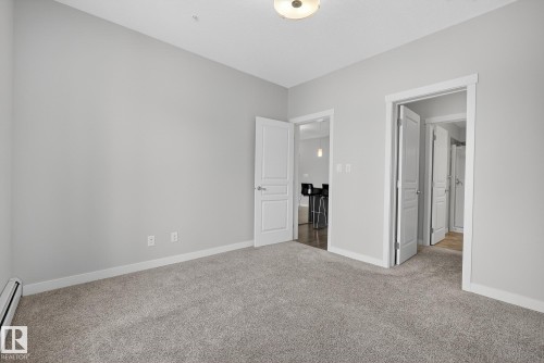 Unfurnished bedroom with carpet and a baseboard heating unit - 206 812 Welsh Drive, Edmonton, AB - Indoor Photo Showing Other Room