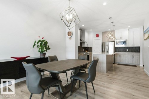 Dining room with hanging lights and light wood finished floors - 8018 Kiriak Link, Edmonton, AB - Indoor Photo Showing Dining Room