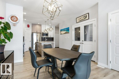 Dining space with light wood-style floors and a chandelier - 8018 Kiriak Link, Edmonton, AB - Indoor Photo Showing Dining Room