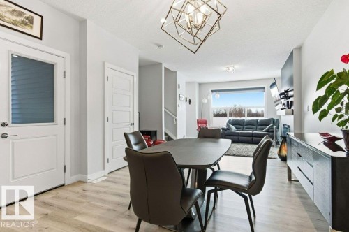 Dining area featuring light wood-style flooring, a textured ceiling, and suspended lighting - 8018 Kiriak Link, Edmonton, AB - Indoor Photo Showing Dining Room