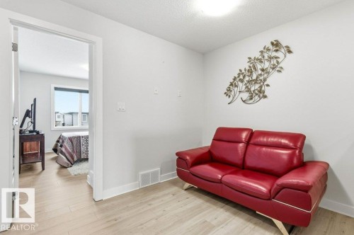Living area with light wood-style floors and a textured ceiling - 8018 Kiriak Link, Edmonton, AB - Indoor