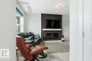 Living area with light wood-type flooring and a glass covered fireplace - 8018 Kiriak Link, Edmonton, AB  - Indoor Photo Showing Living Room With Fireplace 