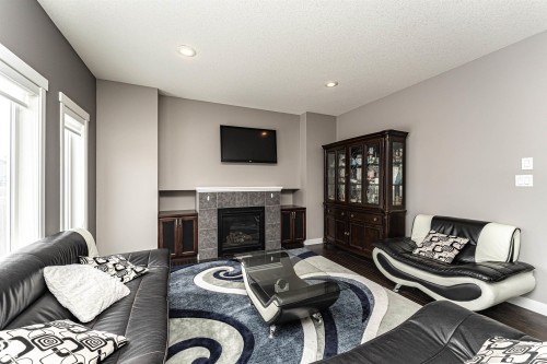 Living room with a fireplace, dark wood-style floors, and recessed lighting - 115 57 Street, Edmonton, AB - Indoor Photo Showing Living Room With Fireplace