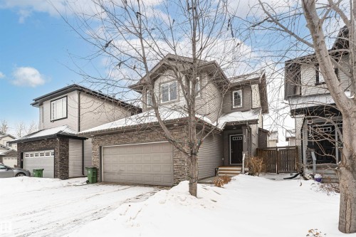 View of front facade with stone siding and an attached garage - 115 57 Street, Edmonton, AB - Outdoor With Facade