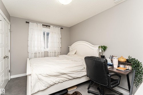 Carpeted bedroom with baseboards and an office area - 115 57 Street, Edmonton, AB - Indoor Photo Showing Bedroom