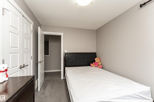 Bedroom with dark colored carpet and a textured ceiling - 115 57 Street, Edmonton, AB - Indoor Photo Showing Bedroom