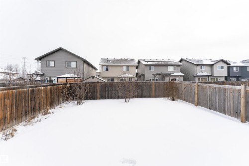 Yard layered in snow with a residential view and a fenced backyard - 115 57 Street, Edmonton, AB - Outdoor