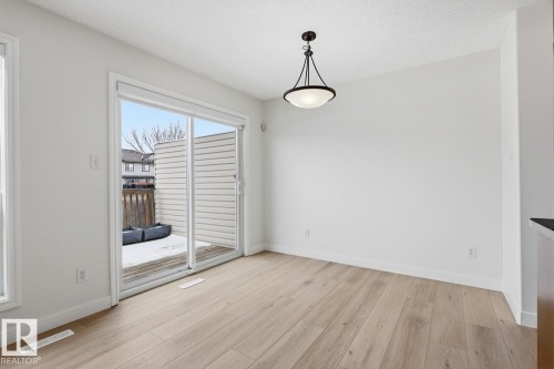 Unfurnished dining area with light wood finished floors and a textured ceiling - 73 Keystone Crescent Crescent, Leduc, AB - Indoor Photo Showing Other Room