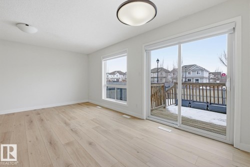 Unfurnished room with a residential view and light wood-type flooring - 73 Keystone Crescent Crescent, Leduc, AB - Indoor Photo Showing Other Room