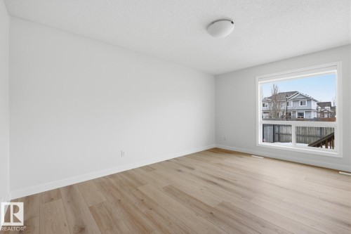 Unfurnished room with light wood-style floors and a textured ceiling - 73 Keystone Crescent Crescent, Leduc, AB - Indoor Photo Showing Other Room