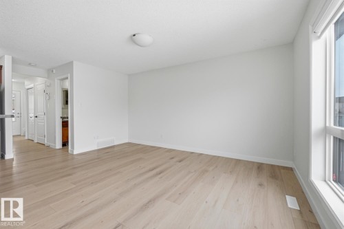 Spare room featuring light wood-style flooring and baseboards - 73 Keystone Crescent Crescent, Leduc, AB - Indoor Photo Showing Other Room With Fireplace