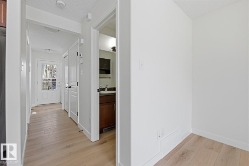 Hallway with light wood finished floors and a textured ceiling - 73 Keystone Crescent Crescent, Leduc, AB - Indoor Photo Showing Other Room