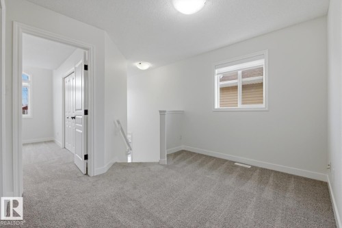 Unfurnished room featuring light colored carpet and a textured ceiling - 73 Keystone Crescent Crescent, Leduc, AB - Indoor Photo Showing Other Room