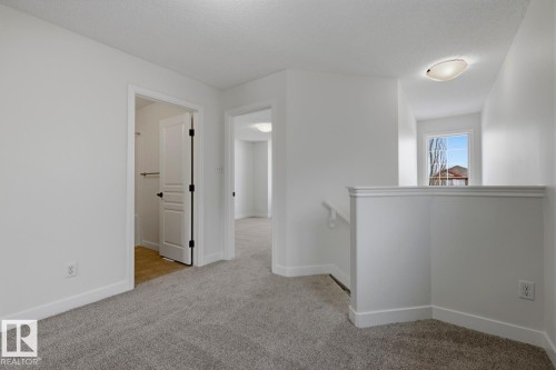 Unfurnished room with baseboards and light carpet - 73 Keystone Crescent Crescent, Leduc, AB - Indoor Photo Showing Other Room