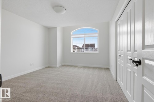 Spare room featuring light colored carpet and a textured ceiling - 73 Keystone Crescent Crescent, Leduc, AB - Indoor Photo Showing Other Room