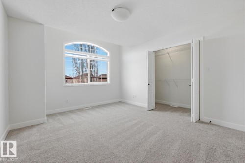 Unfurnished bedroom with light carpet, a closet, and a textured ceiling - 73 Keystone Crescent Crescent, Leduc, AB - Indoor Photo Showing Other Room