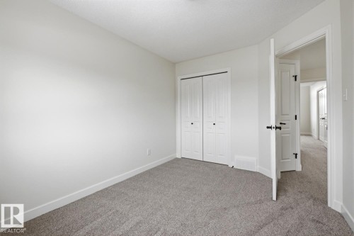 Unfurnished bedroom featuring carpet flooring, a closet, and a textured ceiling - 73 Keystone Crescent Crescent, Leduc, AB - Indoor