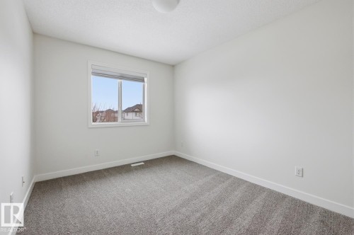 Spare room with light colored carpet and a textured ceiling - 73 Keystone Crescent Crescent, Leduc, AB - Indoor Photo Showing Other Room