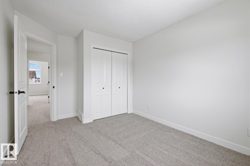 Unfurnished bedroom with light carpet, a closet, and a textured ceiling - 73 Keystone Crescent Crescent, Leduc, AB - Indoor Photo Showing Other Room