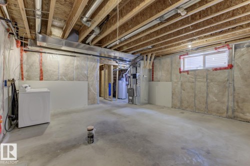 Below grade area featuring washer / dryer, heating unit, and water heater - 73 Keystone Crescent Crescent, Leduc, AB - Indoor Photo Showing Basement