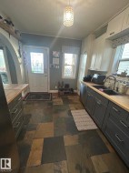 Kitchen with pendant lighting, white cabinets, and plenty of natural light - 