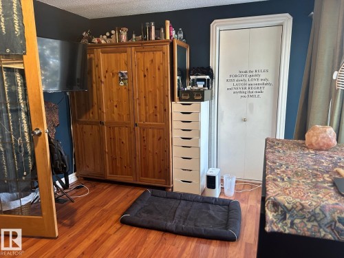 Kitchen featuring wood finished floors, a textured ceiling, and dark countertops - 11406 96 Street, Edmonton, AB - Indoor Photo Showing Other Room