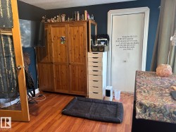 Kitchen featuring wood finished floors, a textured ceiling, and dark countertops - 