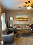 Carpeted living area featuring a ceiling fan and a textured ceiling - 