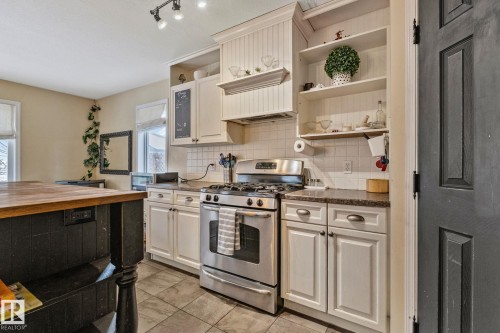 Kitchen featuring stainless steel gas range, backsplash, white cabinets, butcher block counters, and open shelves - 502 Westerra Boulevard, Stony Plain, AB - Indoor Photo Showing Kitchen