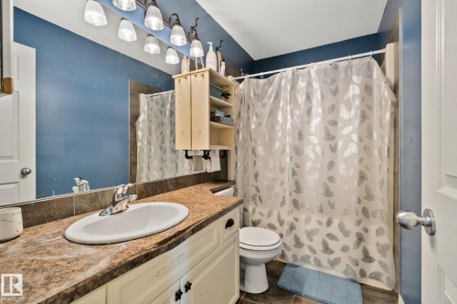 Full bath featuring vanity, a shower with curtain, and dark tile patterned flooring - 502 Westerra Boulevard, Stony Plain, AB - Indoor Photo Showing Bathroom