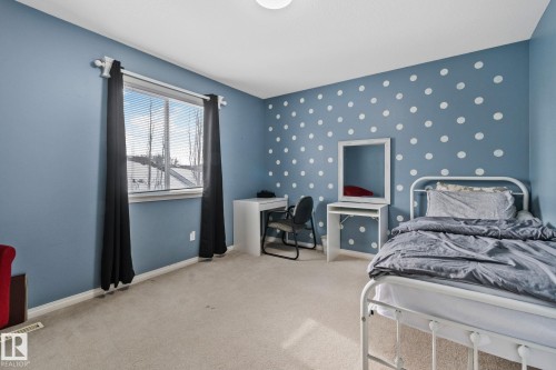 Bedroom with light colored carpet, wallpapered walls, an accent wall, and a desk - 502 Westerra Boulevard, Stony Plain, AB - Indoor Photo Showing Bedroom