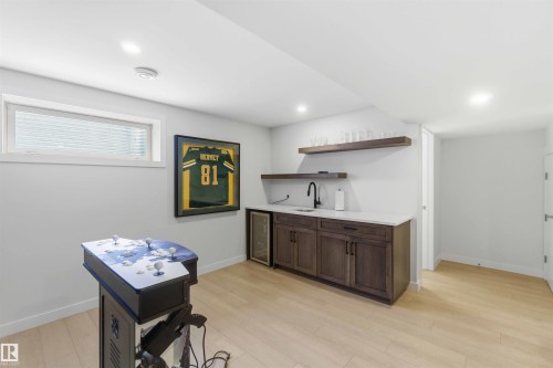 Indoor wet bar with open shelves, wine cooler, dark wood finish cabinetry, light wood-style flooring, and recessed lighting - 2331 71 Street, Edmonton, AB - Indoor