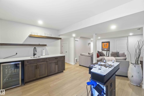 Indoor wet bar with wine cooler, open shelves, light wood finished floors, recessed lighting, and dark wood finish cabinetry - 2331 71 Street, Edmonton, AB - Indoor