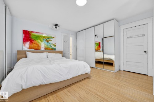Bedroom with two closets and light wood-type flooring - 10523 127 Street, Edmonton, AB - Indoor Photo Showing Bedroom