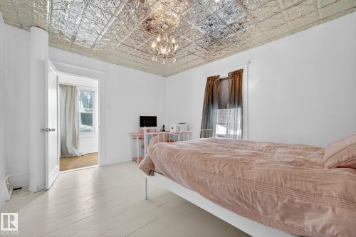 Bedroom with an ornate ceiling, a chandelier, and hardwood / wood-style floors - 10523 127 Street, Edmonton, AB - Indoor Photo Showing Bedroom