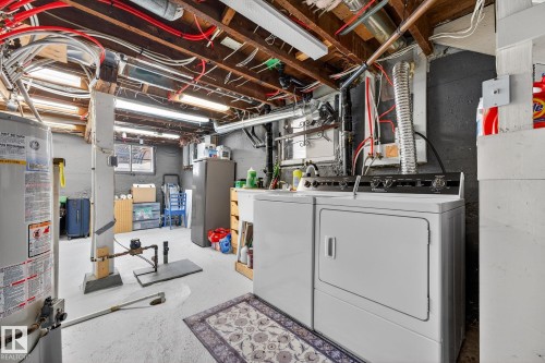 Laundry area featuring gas water heater, concrete floors, and washer and clothes dryer - 10523 127 Street, Edmonton, AB - Indoor