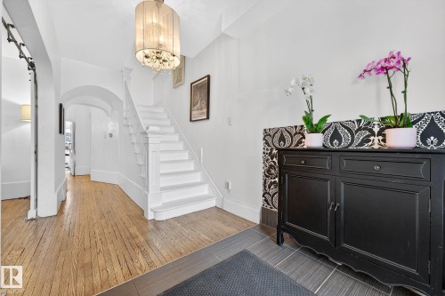 Entrance foyer with arched walkways, light wood finished floors, and a chandelier - 10523 127 Street, Edmonton, AB - Indoor Photo Showing Other Room