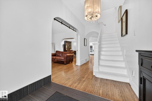 Entrance foyer with arched walkways, light wood finished floors, and suspended lighting - 10523 127 Street, Edmonton, AB - Indoor Photo Showing Other Room