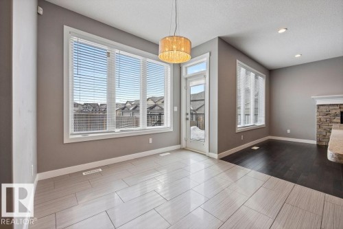 Unfurnished dining area featuring a textured ceiling, recessed lighting, and wood tiled floors - 7515 178 Avenue, Edmonton, AB - Indoor Photo Showing Other Room With Fireplace