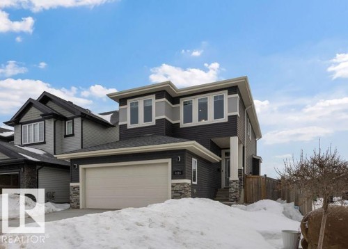 View of front of property featuring stone siding and an attached garage - 7515 178 Avenue, Edmonton, AB - Outdoor With Facade