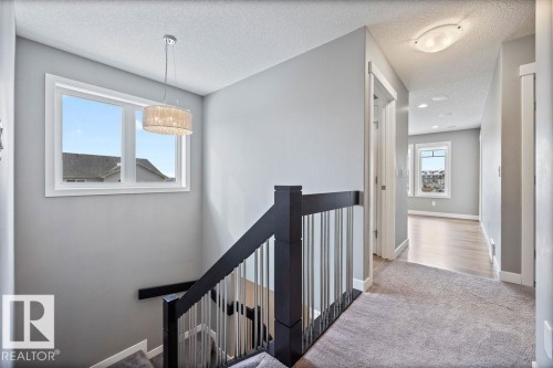 Hallway featuring an upstairs landing, carpet flooring, and a textured ceiling - 7515 178 Avenue, Edmonton, AB - Indoor Photo Showing Other Room