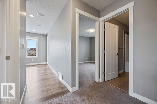 Hallway with a textured ceiling and light carpet - 7515 178 Avenue, Edmonton, AB - Indoor Photo Showing Other Room