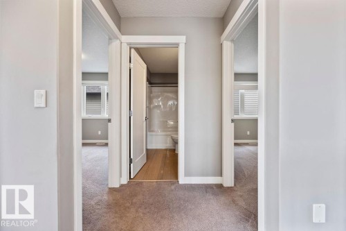 Hallway with dark colored carpet and a textured ceiling - 7515 178 Avenue, Edmonton, AB - Indoor Photo Showing Other Room
