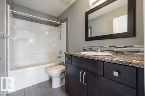 Full bath featuring vanity, bathing tub / shower combination, and tasteful backsplash - 7515 178 Avenue, Edmonton, AB - Indoor Photo Showing Bathroom
