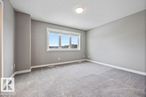 Empty room with a textured ceiling and light colored carpet - 7515 178 Avenue, Edmonton, AB - Indoor Photo Showing Other Room