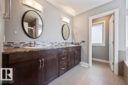 Bathroom featuring double vanity and tasteful backsplash - 7515 178 Avenue, Edmonton, AB - Indoor Photo Showing Bathroom